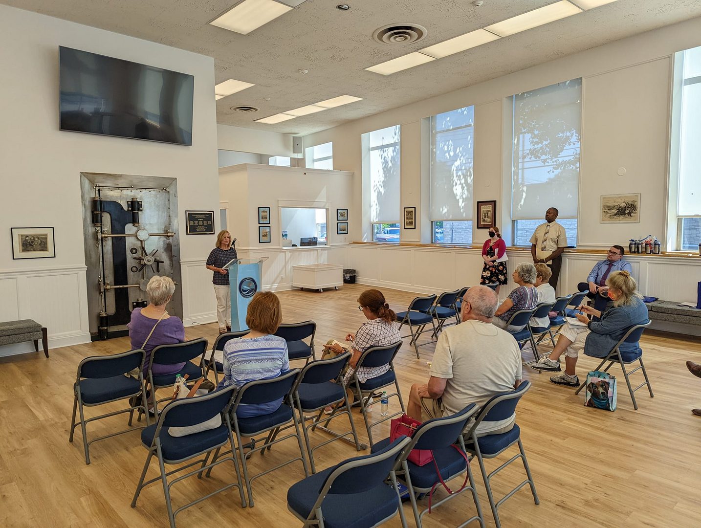 A group of people sitting in chairs inside a room.