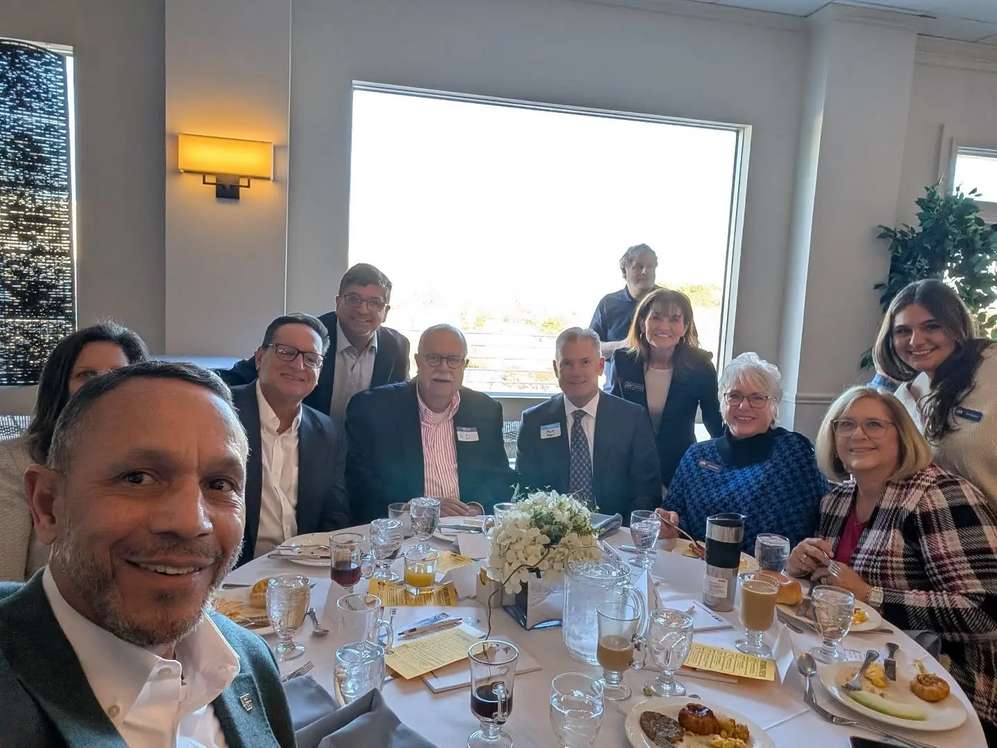 A group of people sitting at a table with food.