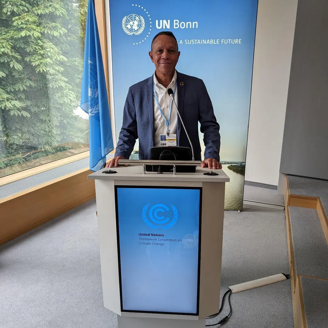 A man standing at the podium in front of an un banner.