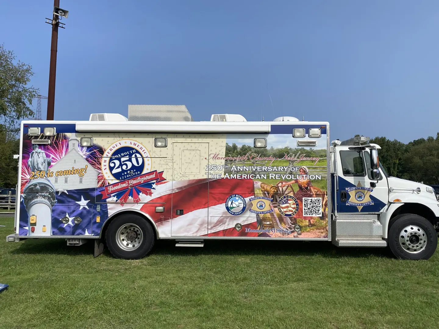 A large white truck parked on top of a grass covered field.