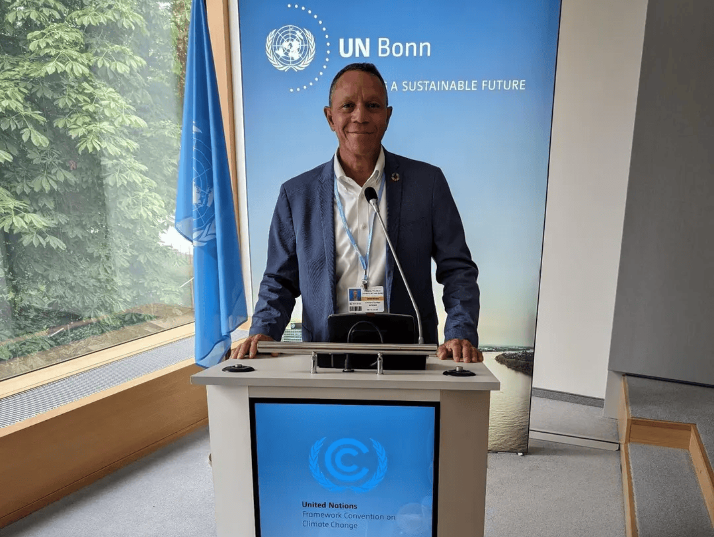 A man standing at the podium in front of a sign.