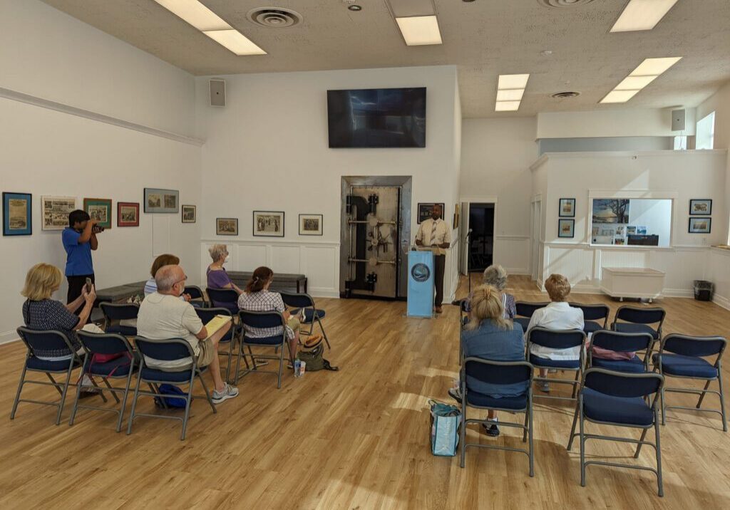 A group of people sitting in chairs in front of a television.